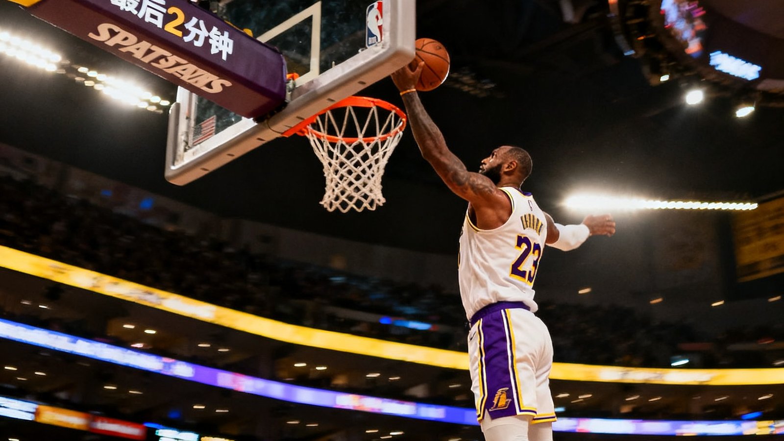 NBA洛杉矶湖人队主场斯台普斯中心，球员飞身扣篮精彩瞬间，篮筐上方计时器显示第四节最后2分钟